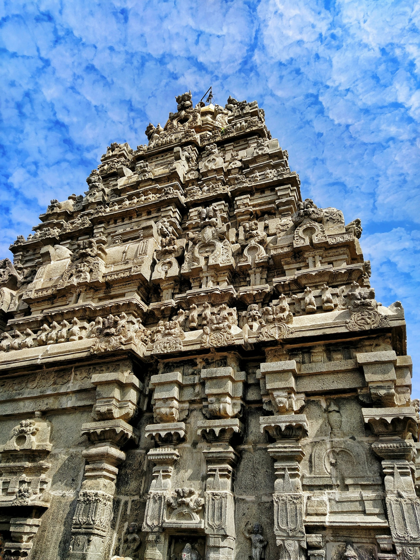 Ornately carved Indian temple architecture beneath a vivid blue sky